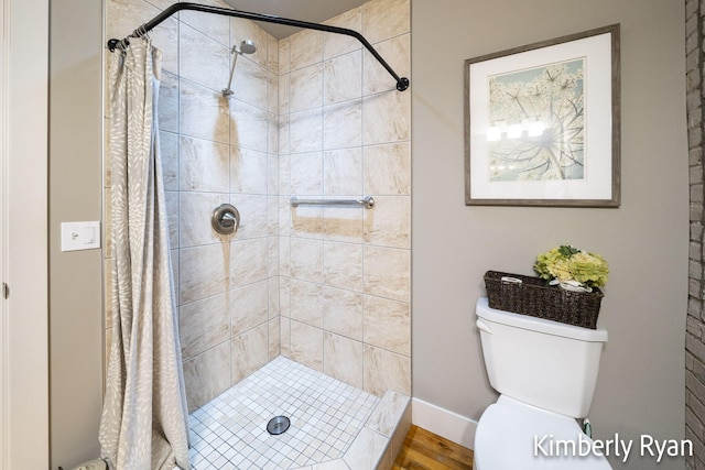 bathroom featuring hardwood / wood-style floors, toilet, and a shower with shower curtain