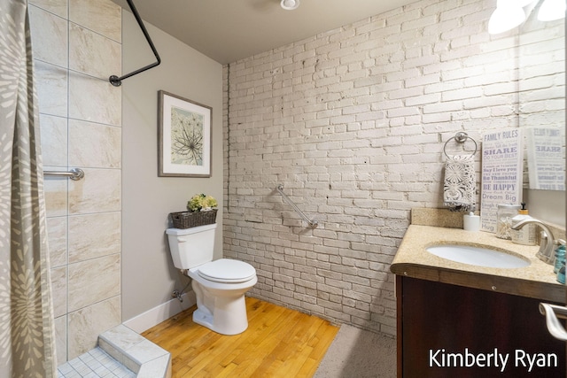 bathroom featuring wood-type flooring, a shower with curtain, vanity, and toilet