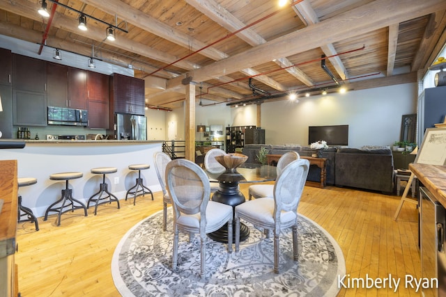 dining area with light wood-type flooring, beam ceiling, wood ceiling, and rail lighting