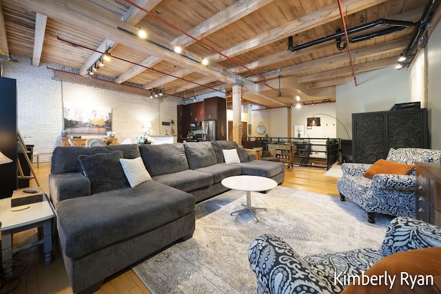 living room with brick wall, light hardwood / wood-style flooring, beam ceiling, and wooden ceiling