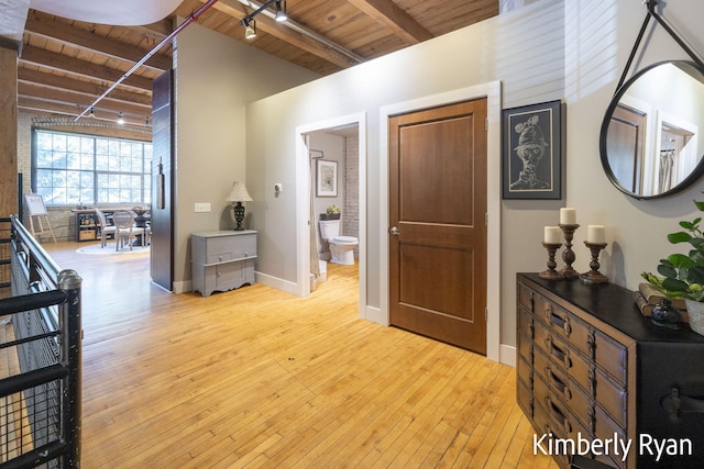 entryway with wooden ceiling, beamed ceiling, and light hardwood / wood-style flooring