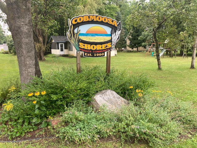 community / neighborhood sign featuring a yard