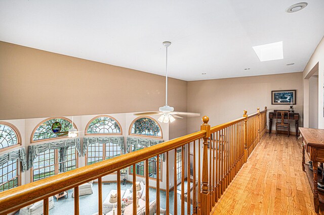 hall featuring hardwood / wood-style floors and a skylight