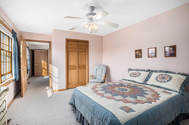 carpeted bedroom with ceiling fan and a closet