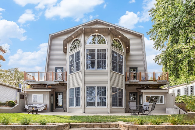 rear view of house with a patio and a balcony