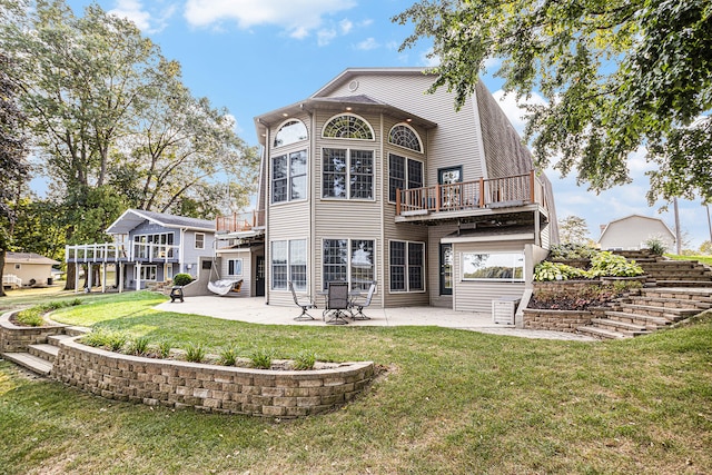 rear view of house featuring a patio area, a yard, and a balcony