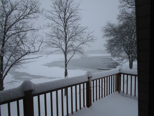 snow covered deck featuring a water view