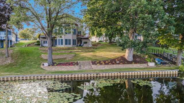 back of house featuring a water view and a yard