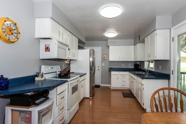 kitchen featuring dark hardwood / wood-style flooring, white cabinetry, sink, and white appliances