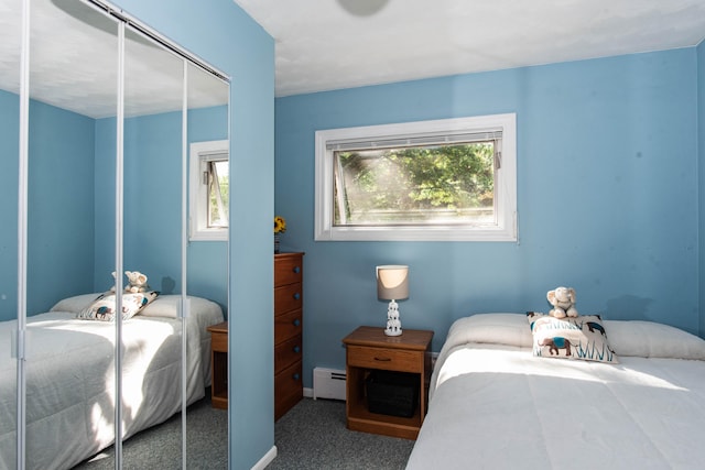 carpeted bedroom featuring a closet and a baseboard heating unit