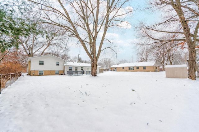 yard layered in snow featuring a shed