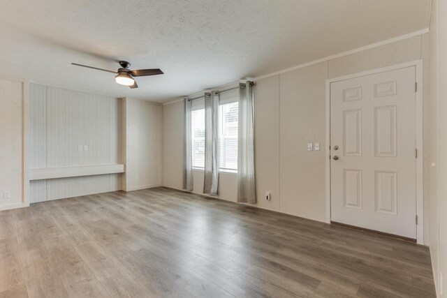 interior space featuring a textured ceiling, crown molding, ceiling fan, and light wood-type flooring