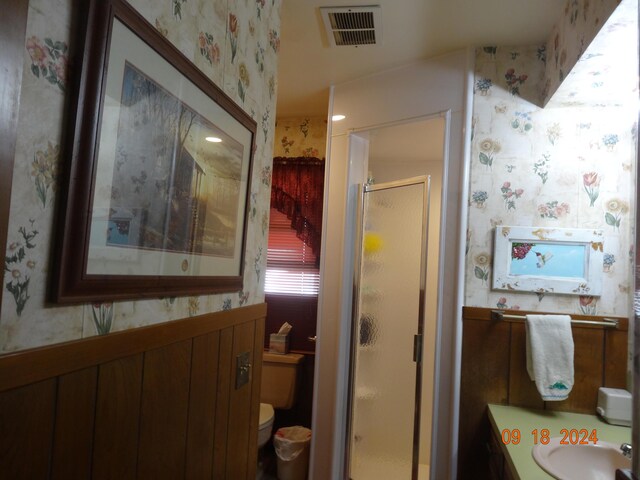 bathroom featuring vanity, toilet, and an enclosed shower