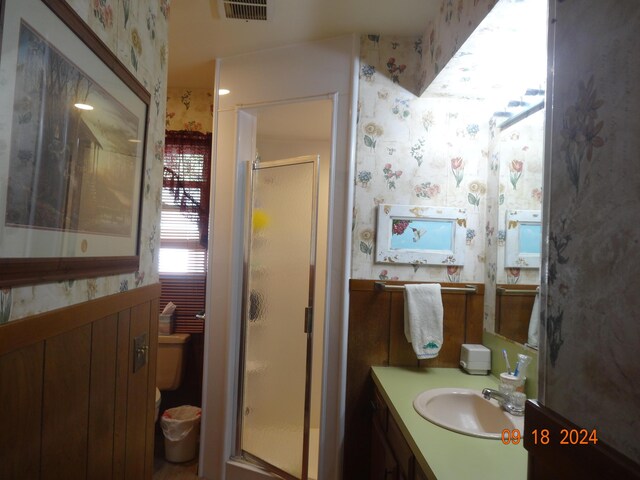 bathroom with an enclosed shower, vanity, and toilet