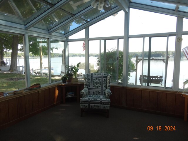 sunroom featuring lofted ceiling, a wealth of natural light, a water view, and ceiling fan