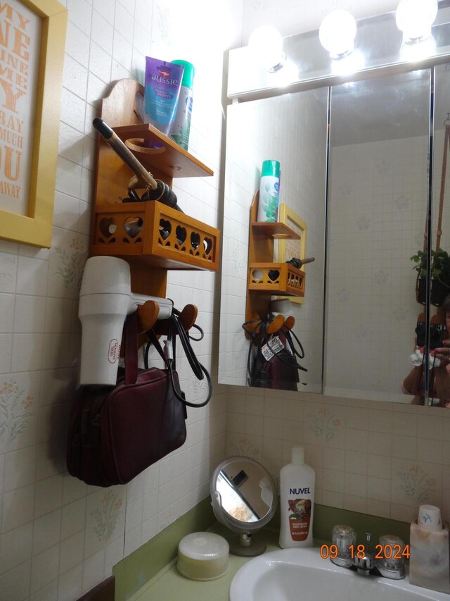 bathroom with tile walls, tasteful backsplash, and sink