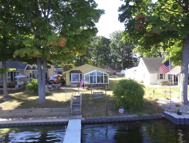 rear view of house featuring a sunroom and a water view