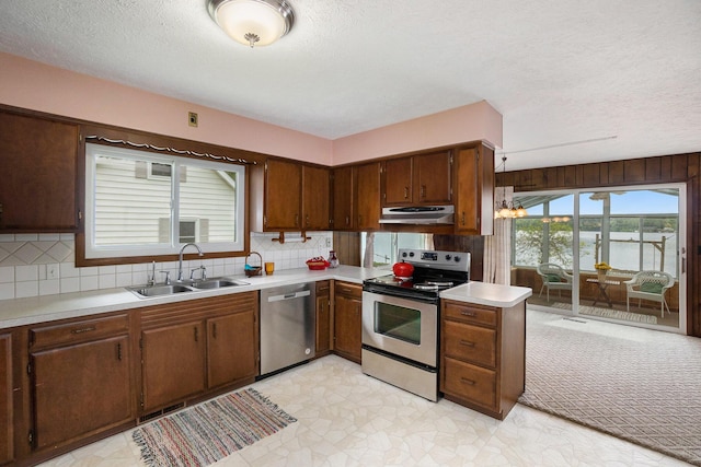 5540 Cozy Point Dr, Newaygo, MI 49337 - kitchen with appliances with stainless steel finishes, under cabinet range hood, a sink, light countertops, and a textured ceiling
