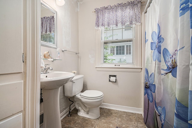 bathroom with tile patterned flooring, toilet, and curtained shower