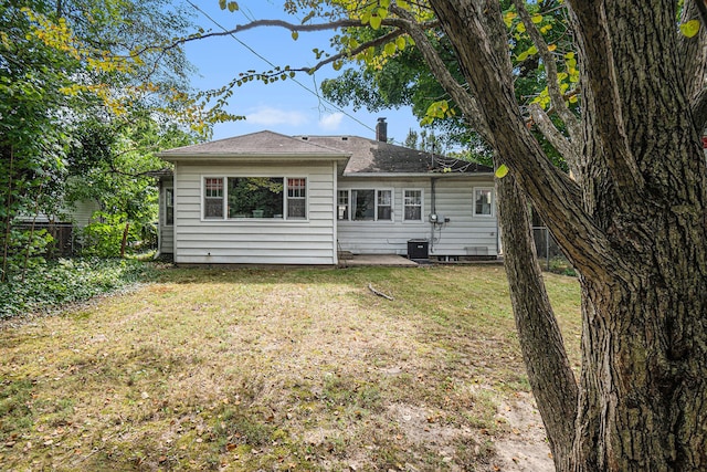 view of front of house with a front lawn and central AC unit