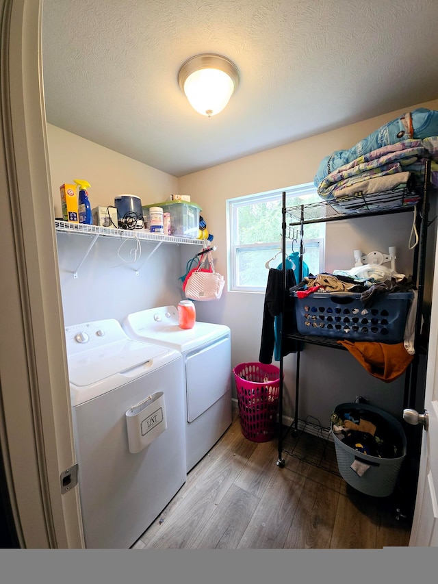 laundry area with separate washer and dryer, a textured ceiling, and wood-type flooring