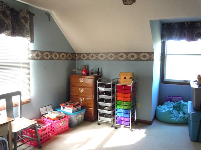 rec room featuring lofted ceiling, a healthy amount of sunlight, and carpet