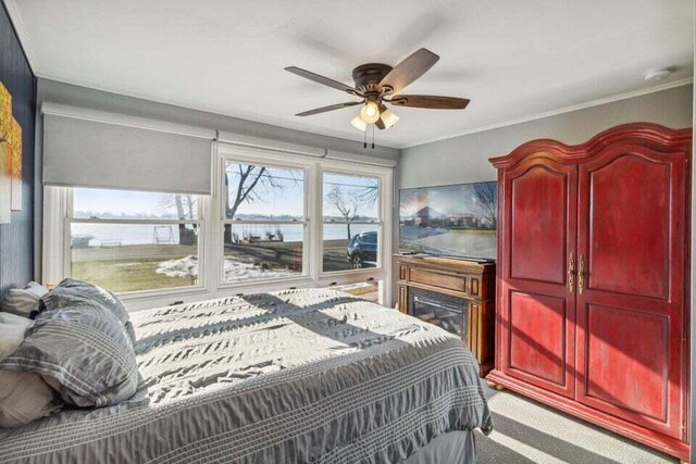 carpeted bedroom with crown molding and ceiling fan