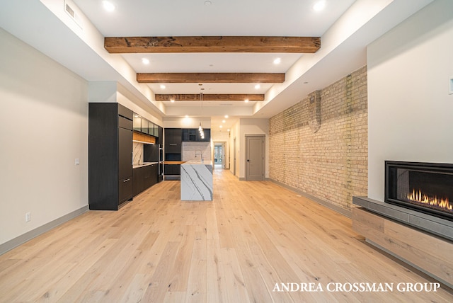 kitchen with light hardwood / wood-style floors, brick wall, beamed ceiling, and sink