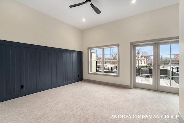 carpeted empty room featuring french doors and ceiling fan