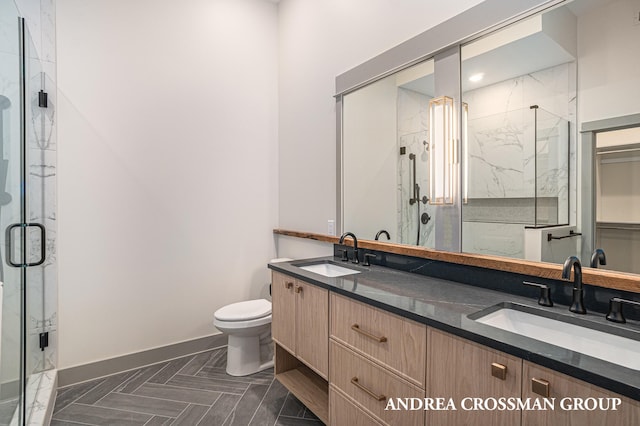 bathroom featuring a shower with door, vanity, parquet flooring, and toilet