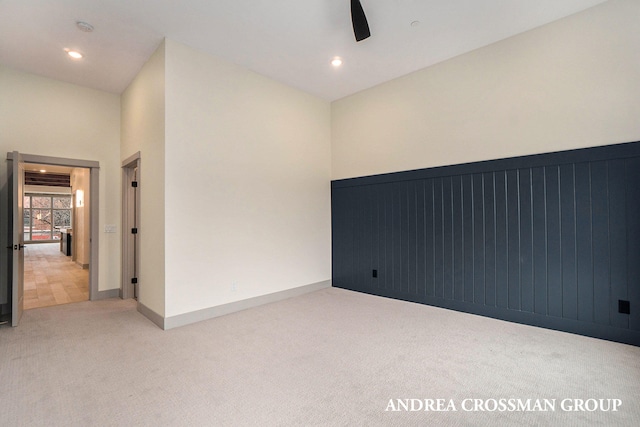 carpeted spare room featuring ceiling fan and high vaulted ceiling