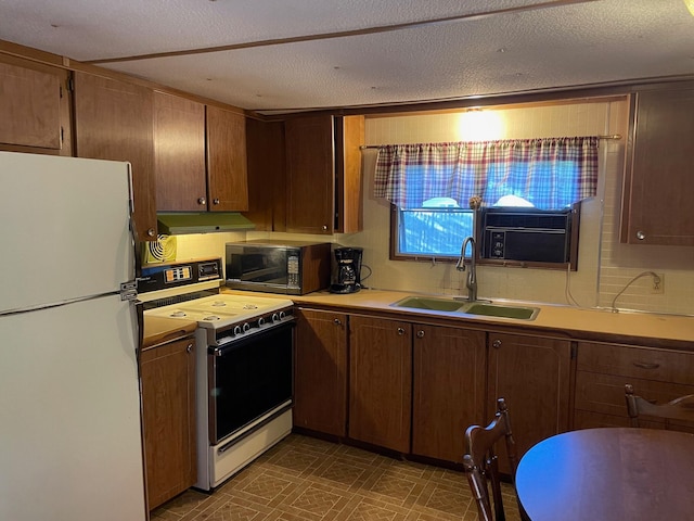 kitchen featuring white appliances, sink, decorative backsplash, and a textured ceiling