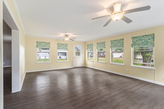 unfurnished living room featuring ornamental molding, ceiling fan, and dark hardwood / wood-style floors