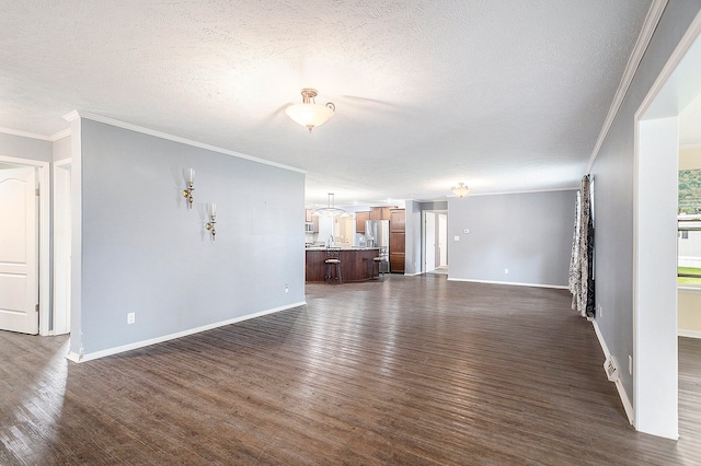 unfurnished living room with crown molding, dark wood-type flooring, and a textured ceiling