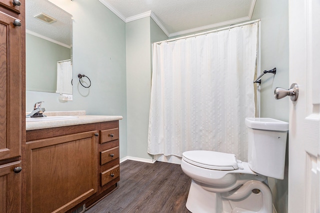 bathroom with a textured ceiling, toilet, wood-type flooring, vanity, and ornamental molding