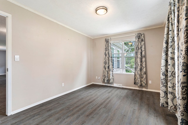 spare room featuring a textured ceiling, ornamental molding, and dark hardwood / wood-style flooring