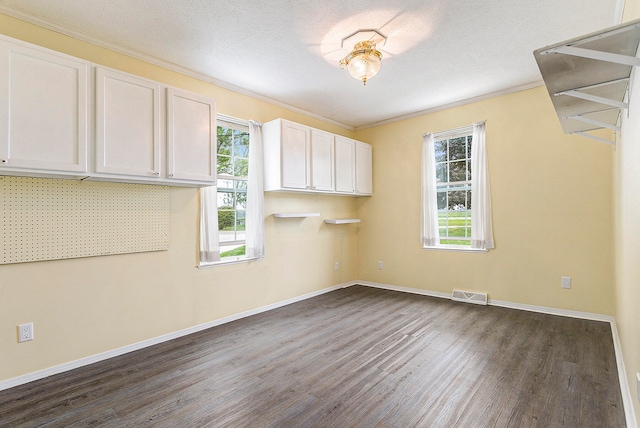 interior space with dark hardwood / wood-style flooring, crown molding, and a textured ceiling