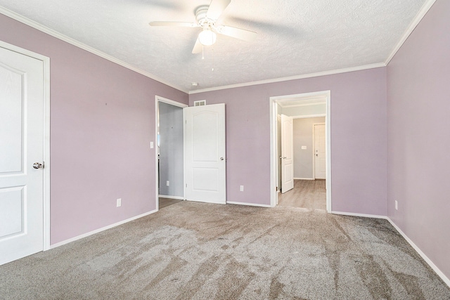 unfurnished bedroom featuring ceiling fan, light colored carpet, ornamental molding, and a textured ceiling