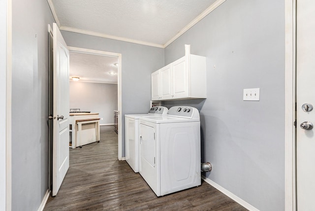 laundry room featuring crown molding, dark hardwood / wood-style flooring, washing machine and clothes dryer, cabinets, and a textured ceiling