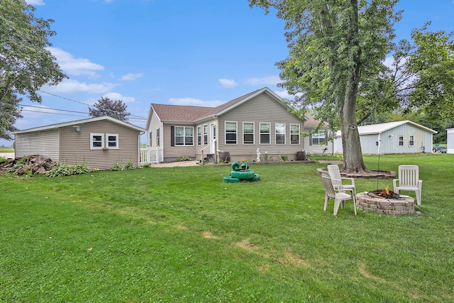 rear view of house featuring a fire pit and a yard