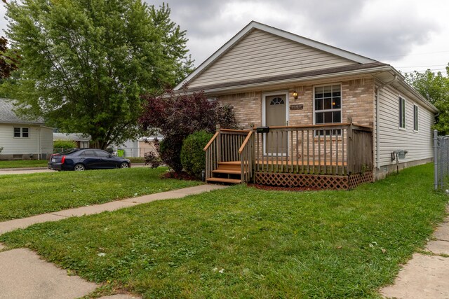 bungalow-style house with a wooden deck and a front yard