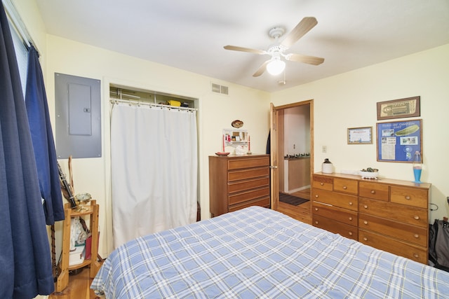 bedroom featuring ceiling fan, hardwood / wood-style floors, a closet, and electric panel