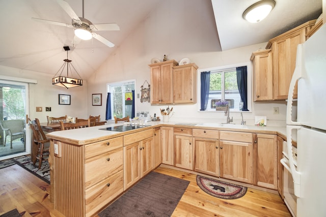 kitchen with kitchen peninsula, light hardwood / wood-style flooring, hanging light fixtures, light brown cabinetry, and white refrigerator