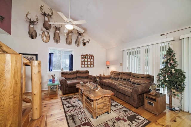 living room with vaulted ceiling, ceiling fan, a wealth of natural light, and light wood-type flooring