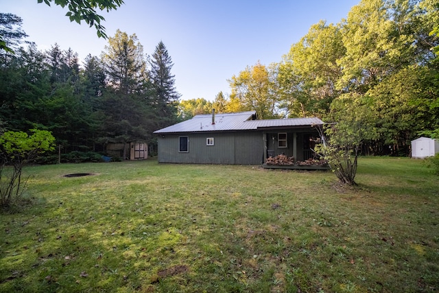 back of property featuring a storage unit and a yard