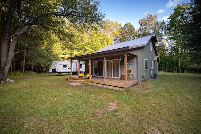 back of house featuring cooling unit and a yard