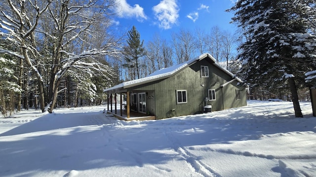 view of snow covered exterior featuring central AC unit