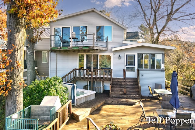 rear view of house featuring a wooden deck and a balcony