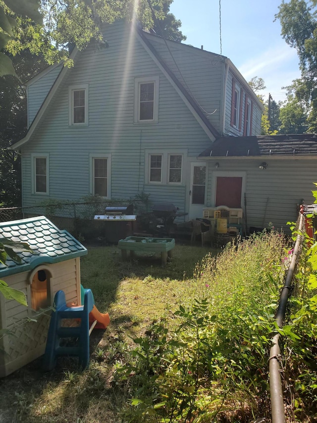 rear view of house featuring a lawn