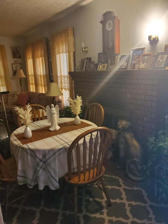 carpeted dining room with a textured ceiling